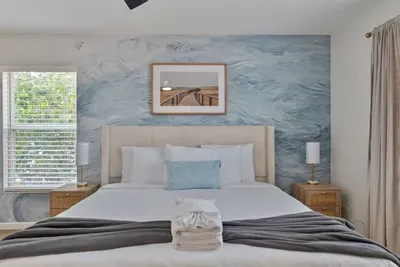 A stylish bedroom design that combines comfort and productivity, featuring a cozy bed adorned with plush pillows and a stylish desk area.