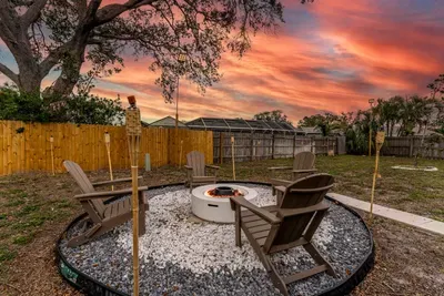 A close-up shot reveals the details of the fire pit surrounded by comfortable seating. The arrangement invites guests to unwind and enjoy warm evenings outdoors, with the natural landscape creating a peaceful backdrop.