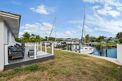 Waterfront deck with cozy seating overlooking calm canals and sailboats. Perfect for morning coffee, sunset lounging, and soaking in peaceful coastal views from your own backyard oasis.