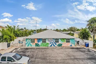 Vibrant, mural-covered exterior with plenty of parking and a welcoming tropical vibe. This colorful coastal retreat offers charm, convenience, and easy access to nearby waterfront adventures.