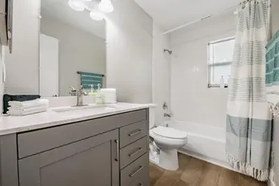 Bright, clean bathroom with a modern vanity, fresh linens, and a spacious tub/shower combo. Soft tones and natural light create a relaxing, spa-like feel—perfect for unwinding after a day of adventure.
