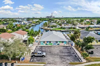 Vibrant coastal property with colorful exterior art, ample parking, and stunning canal views. Perfectly situated for waterfront adventures, this inviting retreat blends charm, convenience, and relaxed island living.
