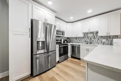 Bright, fully equipped kitchen with sleek stainless appliances, ample counter space, and modern tile backsplash. Perfect for cooking meals together in a stylish, inviting setting.