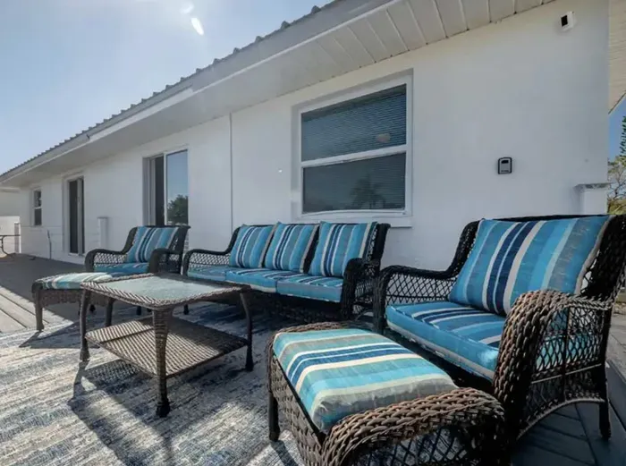 Spacious outdoor deck with comfortable wicker seating and vibrant cushions, perfect for lounging in the sun or enjoying canal views. A serene space to relax, sip coffee, or unwind under the open sky.
