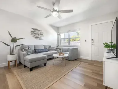 Inviting living room with a plush sectional, cozy textures, and modern coastal décor. Bright natural light, soft tones, and a sleek setup create a perfect space to relax, watch TV, or unwind after a day by the water.