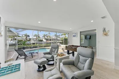 This inviting living area boasts cozy couches with a lovely pool view and a foosball table for friendly competition. Whether you’re relaxing or playing, there’s plenty of space to enjoy your stay.