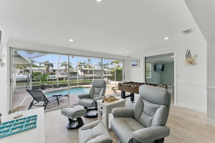 This inviting living area boasts cozy couches with a lovely pool view and a foosball table for friendly competition. Whether you’re relaxing or playing, there’s plenty of space to enjoy your stay.