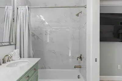 This bathroom features a luxurious bathtub, inviting you to unwind and indulge in a peaceful soak, offering the perfect balance of comfort and relaxation.
