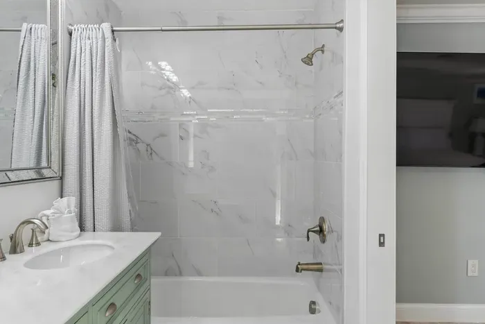 This bathroom features a luxurious bathtub, inviting you to unwind and indulge in a peaceful soak, offering the perfect balance of comfort and relaxation.