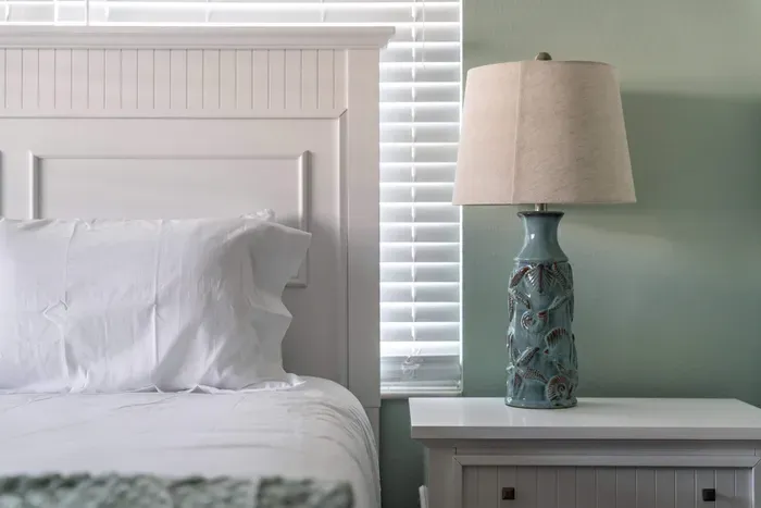 This queen-sized bed is complemented by two side tables and matching lamps, creating a functional yet serene retreat. The ideal setup for comfort and convenience.