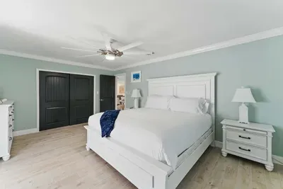Relax in comfort on a plush queen-sized bed, complemented by a stylish, oversized cabinet door that opens up to ample storage space. Perfect for keeping your belongings organized while enjoying a restful night’s sleep in this inviting space.