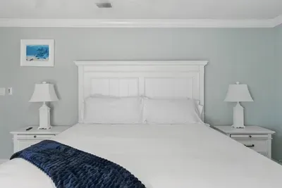 Relax in this inviting queen-sized bed, flanked by two stylish side tables with lamps for reading or setting your essentials. A perfect blend of comfort and functionality.