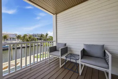 Private balcony with comfortable seating, perfect for morning coffee or evening relaxation. Enjoy fresh air and peaceful neighborhood views in a cozy outdoor space designed to unwind and soak in the surroundings.
