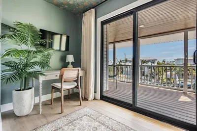 Bright nook with a writing desk and sliding doors opening to a scenic balcony. Perfect for remote work or quiet moments, this inviting corner offers natural light, tropical views, and a refreshing coastal ambiance.