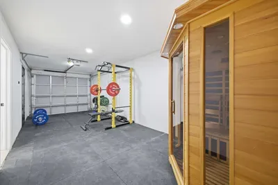 Ultimate wellness space with private sauna and fully equipped gym. Stay active with weights and rack, then unwind and recharge in the sauna—your own personal retreat for fitness and relaxation just steps away.
