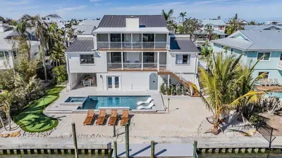 Modern waterfront oasis featuring a private pool, dock, and multiple balconies with stunning canal views. Relax in sun loungers, dine al fresco, or set sail right from your backyard.