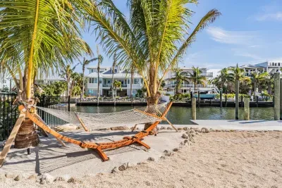 Relax in paradise on a hammock shaded by swaying palms, overlooking serene canal views. This sandy waterfront nook offers the ultimate tropical escape—perfect for morning coffee, afternoon naps, or sunset daydreams by the water’s edge.