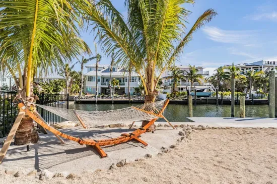 Relax in paradise on a hammock shaded by swaying palms, overlooking serene canal views. This sandy waterfront nook offers the ultimate tropical escape—perfect for morning coffee, afternoon naps, or sunset daydreams by the water’s edge.