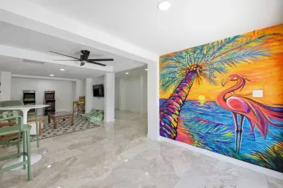 Bright open living space with a bold tropical mural, polished floors, and modern style. Spacious layout flows into dining and kitchen areas, perfect for relaxing or entertaining in a vibrant, stylish setting.