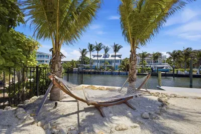 Relax in a shaded hammock under swaying palms, overlooking tranquil waterfront views. This tropical outdoor oasis offers soft sand, gentle breezes, and the perfect spot to unwind, read, or soak in the peaceful coastal vibe.