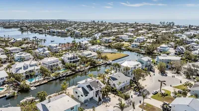 Aerial paradise showcasing crystal-clear canals, luxury coastal homes, and easy ocean access. Perfectly located for boating, beach days, and sunsets, this tropical retreat offers a serene escape with breathtaking island scenery.