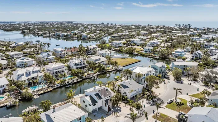 Aerial paradise showcasing crystal-clear canals, luxury coastal homes, and easy ocean access. Perfectly located for boating, beach days, and sunsets, this tropical retreat offers a serene escape with breathtaking island scenery.