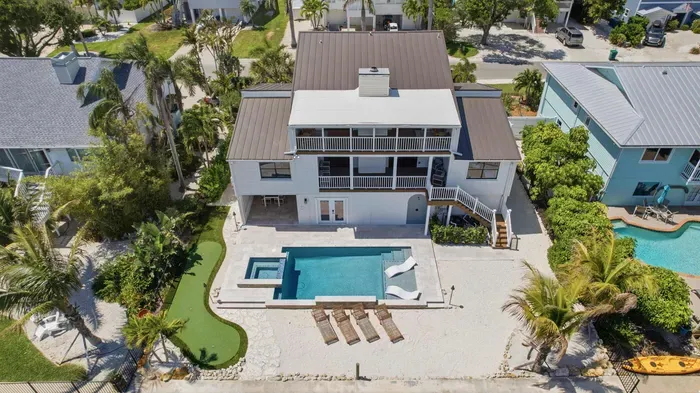 Stunning waterfront escape featuring a private dock, sparkling pool, and multiple balconies with breathtaking sunset views.