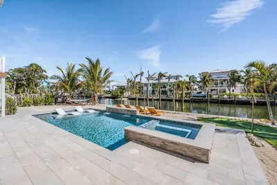 Gorgeous outdoor oasis with a sparkling pool, spa, and canal views framed by swaying palms. Perfect for sunbathing, swimming, or relaxing by the water in your private slice of tropical paradise.