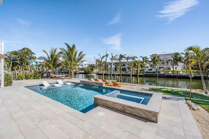 Gorgeous outdoor oasis with a sparkling pool, spa, and canal views framed by swaying palms. Perfect for sunbathing, swimming, or relaxing by the water in your private slice of tropical paradise.