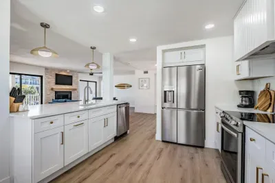 Bright and modern kitchen with stainless steel appliances, sleek white cabinetry, and elegant pendant lighting. The open layout connects seamlessly to the living area, creating the perfect space for cooking, entertaining, and gathering with loved one