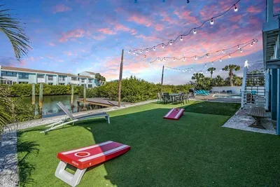 Waterfront fun under the string lights! Enjoy games on the turf, lounge by the dock, or watch the sunset over the water. This vibrant outdoor space is perfect for family gatherings, laughter, and unforgettable evenings.