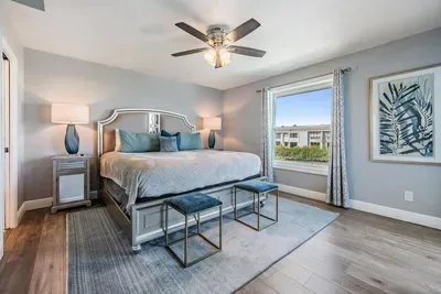 Bedroom 4 offers a spacious retreat with a king bed, elegant décor, and large windows filling the room with natural light. Modern touches and cozy details create a serene space for restful nights and refreshing mornings.