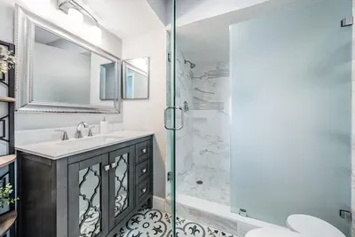 Bathroom 3 offers modern elegance with a sleek vanity, glass-enclosed shower, and chic tile details. Designed for style and convenience, this refreshing space ensures guests enjoy both comfort and functionality.