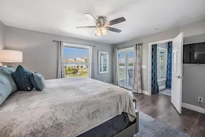 Bedroom 4 offers a king bed retreat with private balcony access, where guests can wake up to fresh air and serene views. Bright, modern décor and cozy details make this space perfect for relaxation and restful nights.