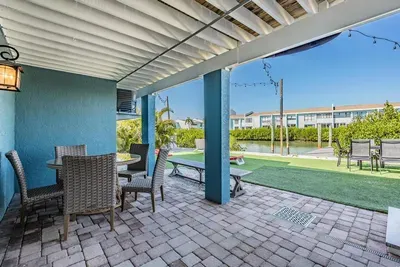 Relax in the shaded outdoor patio featuring cozy dining, string lights, and views of the lush yard. Perfect for morning coffee, family meals, or evening cocktails while enjoying the Florida breeze.