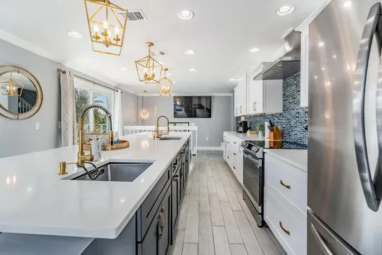 Sleek quartz counters, custom cabinetry, stainless steel appliances & designer lighting create a modern, elegant space. Perfect for cooking, entertaining & gathering in style.