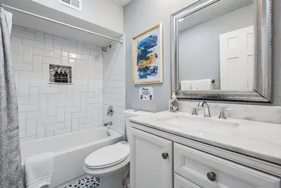 Bathroom 2 offers convenience and style with a sleek vanity, bright lighting, and a tub/shower combo surrounded by modern tile. A shared space designed for comfort, making it perfect for families or groups.