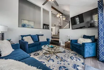 Modern second living room designed for comfort & style! Featuring chic blue seating, cozy accents, a large flat-screen TV, and open layout with vaulted ceilings—perfect for lounging, movie nights, or family fun.