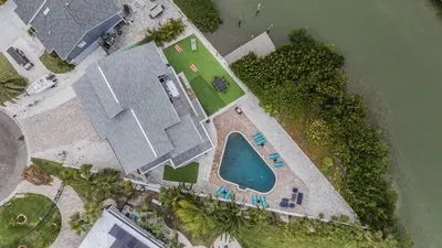 This stunning retreat boasts a private dock, sparkling pool, and spacious outdoor lounge areas. Relax, entertain, and soak in breathtaking views your perfect escape on the water awaits!