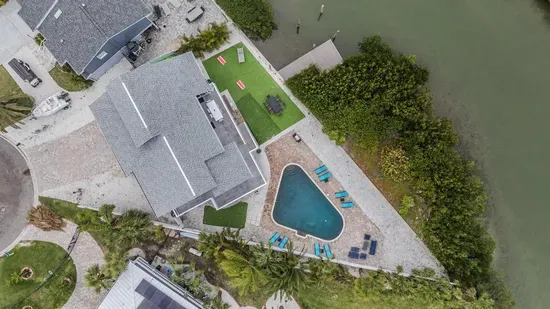 This stunning retreat boasts a private dock, sparkling pool, and spacious outdoor lounge areas. Relax, entertain, and soak in breathtaking views your perfect escape on the water awaits!