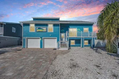 Stunning coastal home with bold curb appeal! Featuring a spacious driveway, modern architecture, and inviting balconies, this property welcomes guests with style and comfort—perfect for your dream waterfront getaway.