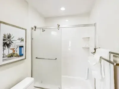 Modern bathroom featuring a sleek glass shower, bright lighting, and clean white finishes. Thoughtful touches and spa-like details create a refreshing, relaxing space to start or end your day.