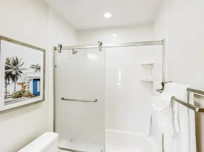 Modern bathroom featuring a sleek glass shower, bright lighting, and clean white finishes. Thoughtful touches and spa-like details create a refreshing, relaxing space to start or end your day.