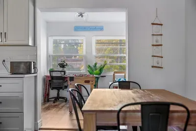 Light-filled dining space with an open flow into a sunny bonus room! Enjoy a spacious table for meals and game nights, plus a dedicated workspace with large windows and natural light. A perfect blend of comfort, function, and vacation-ready style.