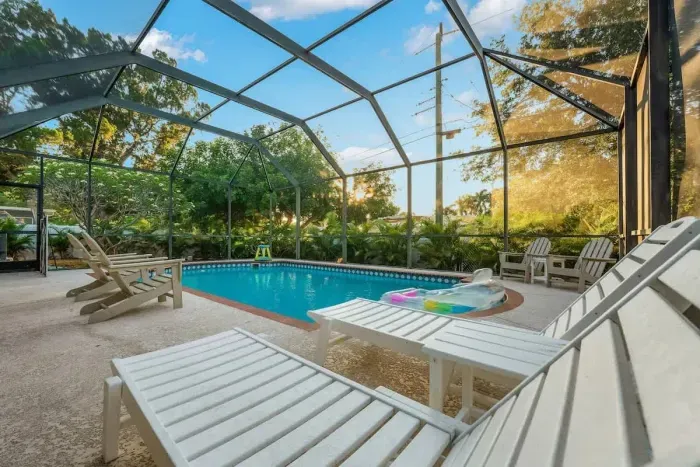 Unwind in your own private screened-in pool paradise! Stretch out on lounge chairs, soak up the sunshine, and enjoy peaceful tropical views all around.
