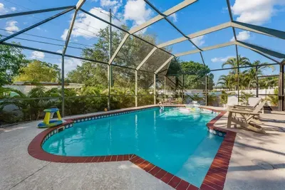 Sparkling turquoise water, brick-trimmed deck, and plenty of space to lounge in the sun. Surrounded by lush tropical landscaping for added privacy—perfect for relaxing, entertaining, and year-round Florida fun.