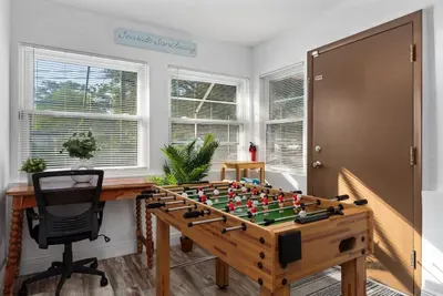 Bright, fun-filled bonus room perfect for work and play! Enjoy a dedicated desk space, sunlit windows, and a foosball table for friendly competition. This cheerful retreat is ideal for remote work, game nights, or relaxing between adventures.