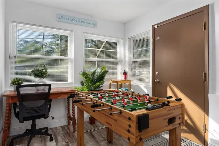 Bright, fun-filled bonus room perfect for work and play! Enjoy a dedicated desk space, sunlit windows, and a foosball table for friendly competition. This cheerful retreat is ideal for remote work, game nights, or relaxing between adventures.