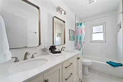 Fresh, bright, and beautifully updated bathroom featuring a spacious double vanity, modern fixtures, and plenty of lighting. Enjoy a clean tub/shower combo, and a spa-like feel—perfect for getting ready comfortably during your stay.