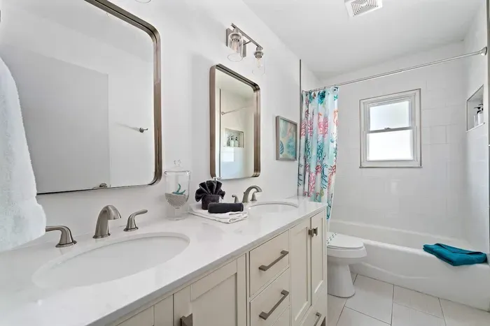 Fresh, bright, and beautifully updated bathroom featuring a spacious double vanity, modern fixtures, and plenty of lighting. Enjoy a clean tub/shower combo, and a spa-like feel—perfect for getting ready comfortably during your stay.
